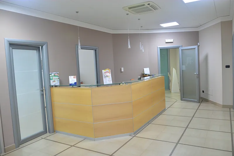 Il bancone della reception e le porte degli studi
